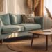 A sunlit living room featuring a light blue sofa, patterned cushions, and natural textures—like a woven rug and wooden coffee table with pampas grass—beautifully captures the inviting, relaxed vibe of boho home décor.